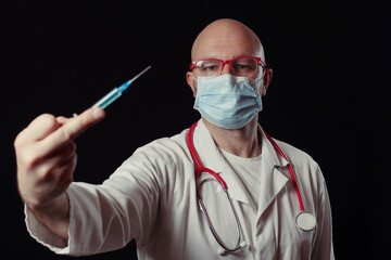 Bald male doctor showing middle finger gesture with syringe in focus. Negative attitude toward...