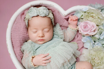 Fototapeta na wymiar Newborn girl on a pink background. Photoshoot for the newborn. A portrait of a beautiful sleeping newborn baby girl