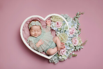 Newborn girl  on a pink background. Photoshoot for the newborn.  A portrait of a beautiful ...