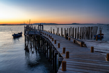 Fototapeta premium Comporta wooden stilt pier at sunset in Setúbal, Portugal. 