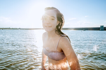 Teen girl playing in lake on a sunny day