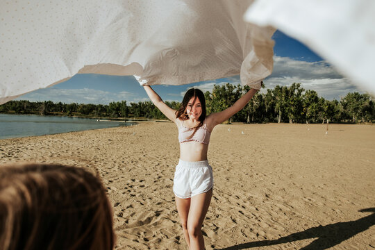 Teen girl playing with younger sister on sandy beach