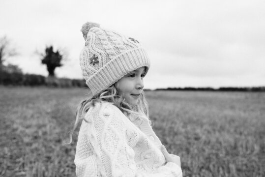 portrait of a girl cosy in a cardigan whilst playing outside