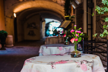 A small bouquet decorates empty tables in a European-style cafe for an intimate setting.