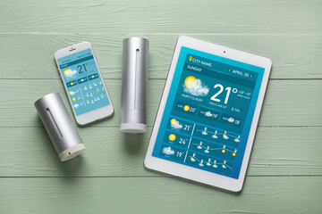 Weather forecast equipment and mobile phone with tablet computer on wooden background