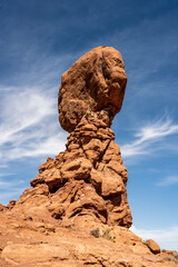 Fototapeta na wymiar Looking Up At The Balanced Rock With Streaking Clouds On A Blue Sky