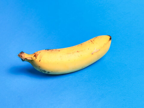 Photo of ripe banana against blue background.