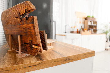 Holder with cutting board on wooden table top in kitchen