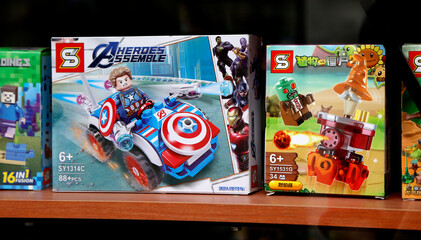 Obraz premium Toys of Chinese origin imitation of toys of famous people. Lego-type toys. Captain America, Plants versus zombies, Minecraft. Boxes of children's toys in a toy store window. Fake toys.