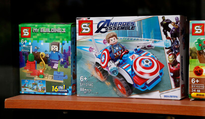 Obraz premium Toys of Chinese origin imitation of toys of famous people. Lego-type toys. Captain America, Plants versus zombies, Minecraft. Boxes of children's toys in a toy store window. Fake toys.