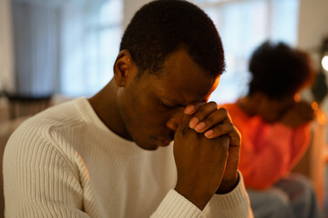 Selective focus of upset depressed african man with closed eyes feeling heartbroken after break up with girlfriend at home, frustrated black guy thinking about difficult or disappointment marriage