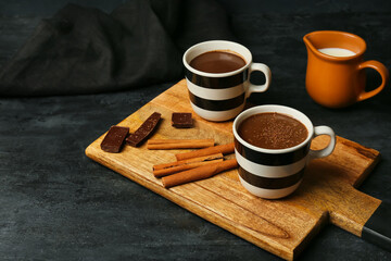 Fototapeta na wymiar Cups of natural hot chocolate on black background