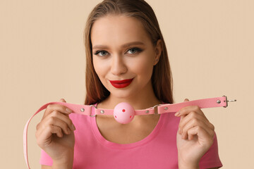 Young woman with mouth gag on light background - obrazy, fototapety, plakaty