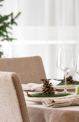 Beautiful table setting with pine cones and fir branches indoors