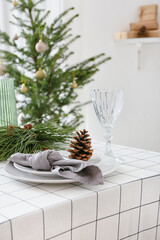 Beautiful table setting with pine cones and fir branches indoors