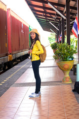 young asian woman smilingTraveler girl walking and waits train on railway platform