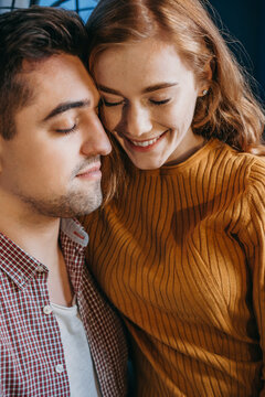 Close Up Portrait Of A Loving Young Couple Embracing Each Other With Closed Eyes. Smiling Face. Front View. Family