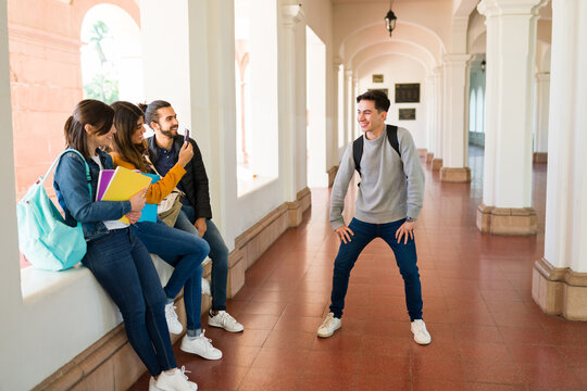 Cheerful friends laughing at a young man