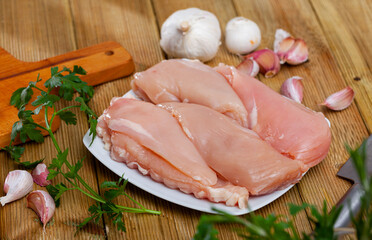 Raw poultry, fresh chicken breast with condiments on wooden table