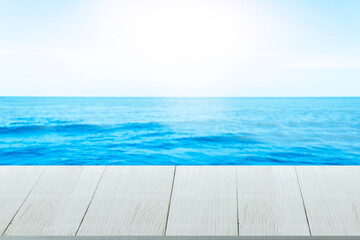 Beautiful wooden floor and blue background, sea water and sky.