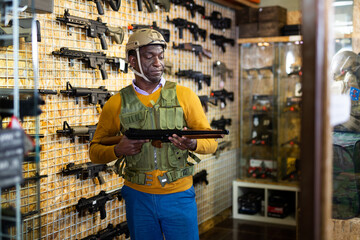 African american man in army uniform with weapon in military market