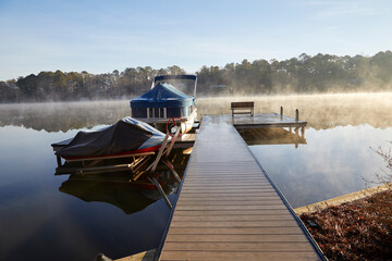 My boat dock on a beautiful morning with fog steaming from the lake - obrazy, fototapety, plakaty
