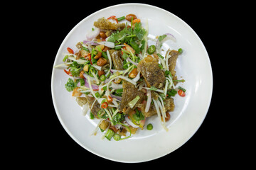 Die cut of Salad Crispy Gourami Fish with Spicy Seafood Sauce on black isolated.