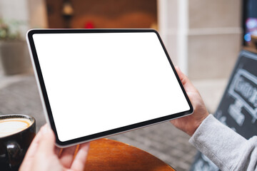 Mockup image of a woman holding digital tablet with blank white desktop screen in the outdoors - obrazy, fototapety, plakaty