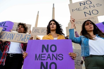 Low angle view: multi-ethnic women activist demonstrate for woman's right march in the street with...