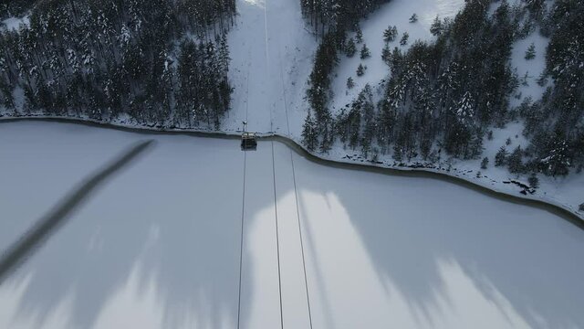 Aerial View, Zlatibor Gondola Lift in White Winter Landscape, Snow Capped Hills, Frozen Ribnica Lake Under Tornik Ski Center - Drone Shot