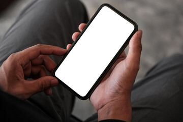 Close up view man holding mock up smart phone. Blank screen for your advertising text.