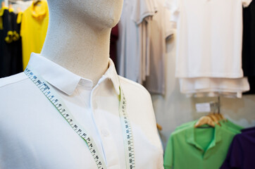 Mannequin with white shirt and waist measuring tape in clothing store