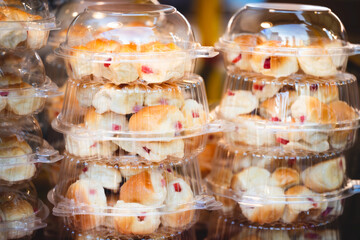 Sausage bread in transparent round box. Bakery and snacks. It looks like bread sticks on tongue.