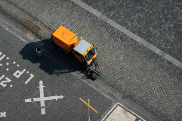 Travel during COVID-19 pandemic. Cleaning the streets and the old town square of Prague, Czech Republic. View from above of an electrical car used to mentain the cities clean.