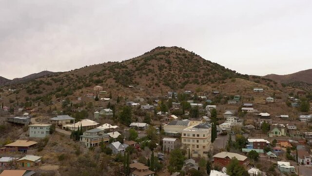 Drone ascending over old mining town Bisbee Arizona, daytime overcast sky