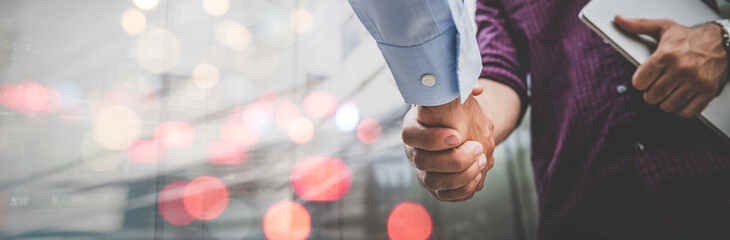 Two businessman shaking hands with business deals and congratulations on success, panorama image...