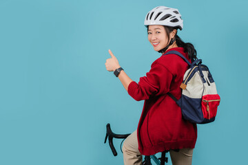 Asian beautiful woman is riding a city bike to work and thumbs up showing great symbol