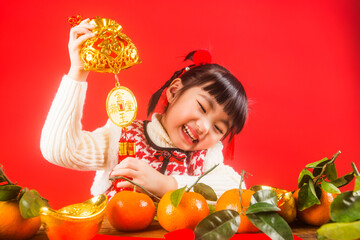 Fototapeta na wymiar A Chinese girl celebrates the Spring Festival with gold ingots