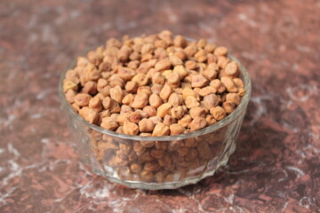 A bowl of fresh unpeeled chickpeas on tile