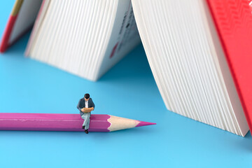 Reader on pencil next to miniature creative book