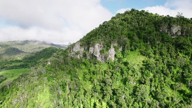 Drone shot of rocky outcrop on green Australian mountain with gumtrees