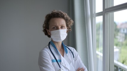 Portrait of female doctor seriously looking at the camera, solving medical issues, worrying about a global pandemic