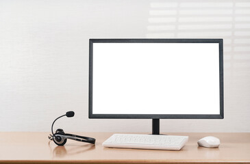 Front view of plain workspace with modern computer and headset headphones. Mockup screen for your text or advertising content. Call center, customer support, Working from home