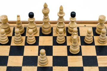 White wooden chess pieces arranged on a chessboard