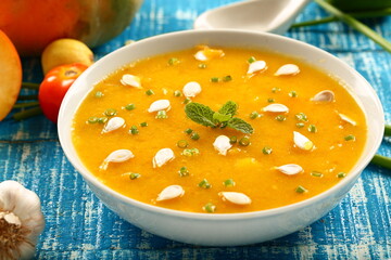Healthy vegan diet meal- bowl of delicious organic pumpkin soup garnished with pumpkin seeds.