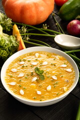Bowl of delicious vegan diet meal- healthy organic pumpkin soup with fresh cream.