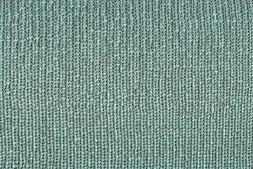 Background of coarse knitting made of wool. English elastic wool. Warm knitted fabric. Abstract background of rough hand knitting.