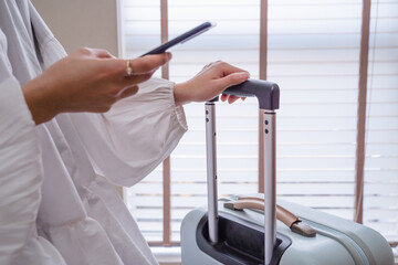 ビジネス素材　空港の待ち時間でスマホを打つ女性