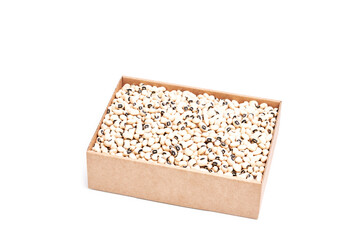Pile of small raw white beans in a cardboard box on a white background