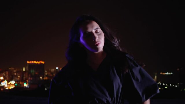 Stylish female on terrace in night city